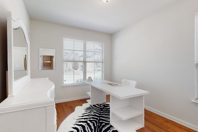 office space with baseboards and wood finished floors