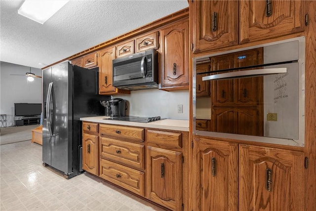 kitchen with light countertops, brown cabinetry, and black appliances