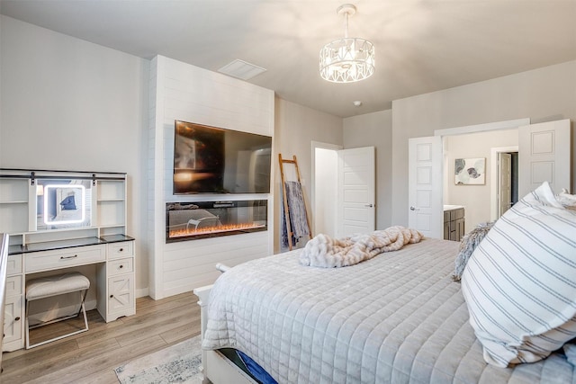 10600 Barrington Ln, Fort Worth, TX 76126 - bedroom featuring baseboards, light wood finished floors, a glass covered fireplace, and a notable chandelier