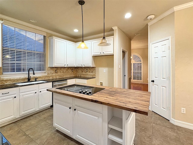 kitchen featuring crown molding, stainless steel appliances, butcher block countertops, and a sink