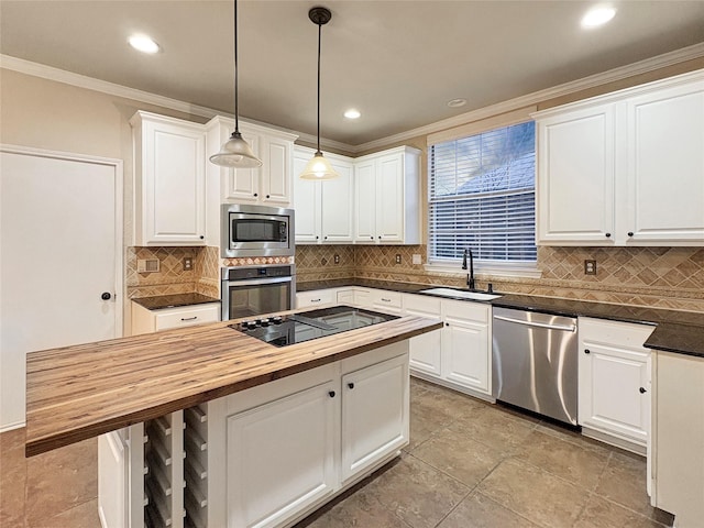 kitchen featuring stainless steel appliances, a sink, a center island, decorative backsplash, and butcher block countertops