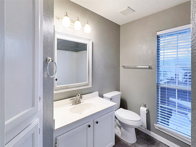 bathroom featuring tile patterned flooring, toilet, vanity, visible vents, and a textured ceiling