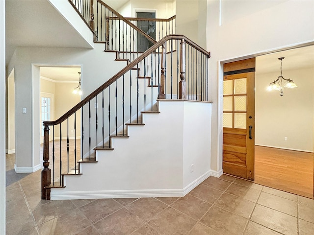 empty room with a barn door, baseboards, wood finished floors, and a chandelier