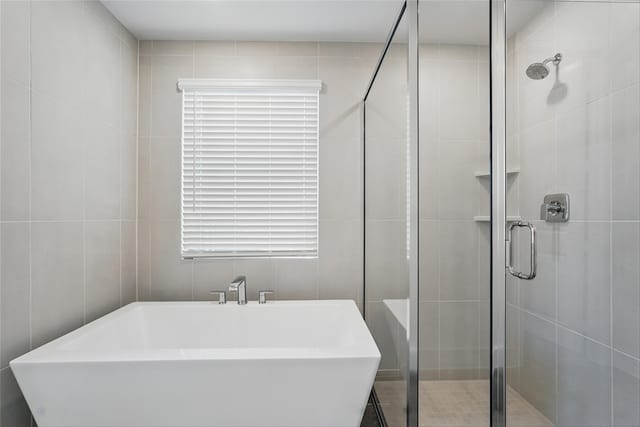2836 Holland Ct, Celina, TX 75009 - full bathroom featuring tile walls, a shower stall, and a soaking tub