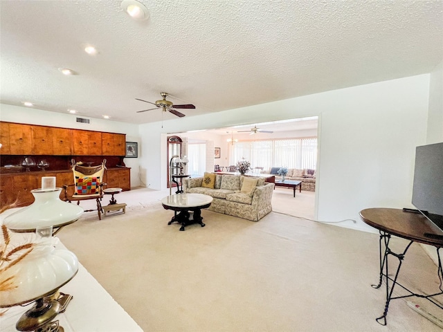 220 N 15th Ave, Munday, TX 76371 - living room featuring carpet flooring, a ceiling fan, a textured ceiling, and visible vents