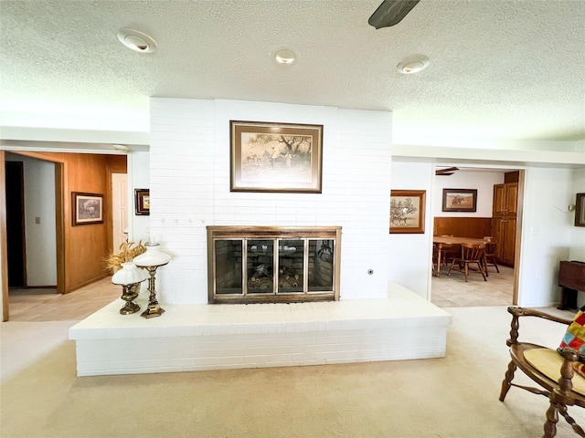 220 N 15th Ave, Munday, TX 76371 - living area with light carpet, a ceiling fan, wood walls, and a brick fireplace