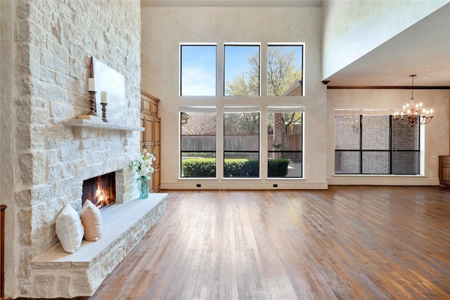 5460 Stone Canyon Dr, Frisco, TX 75034 - unfurnished living room featuring a high ceiling, wood finished floors, a chandelier, and a fireplace