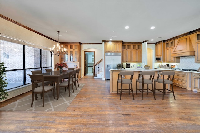 5460 Stone Canyon Dr, Frisco, TX 75034 - kitchen featuring built in appliances, custom range hood, arched walkways, crown molding, and a kitchen island