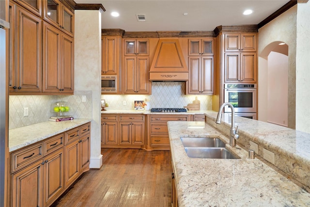 5460 Stone Canyon Dr, Frisco, TX 75034 - kitchen featuring visible vents, a sink, premium range hood, arched walkways, and stainless steel appliances