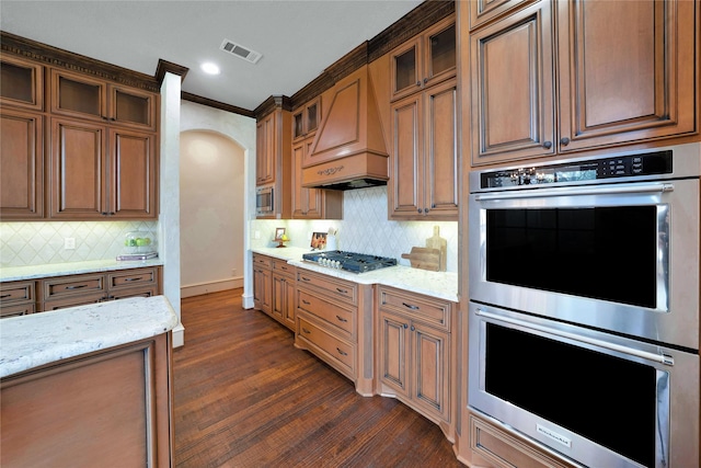 5460 Stone Canyon Dr, Frisco, TX 75034 - kitchen featuring stainless steel appliances, visible vents, dark wood-style flooring, light stone counters, and custom range hood
