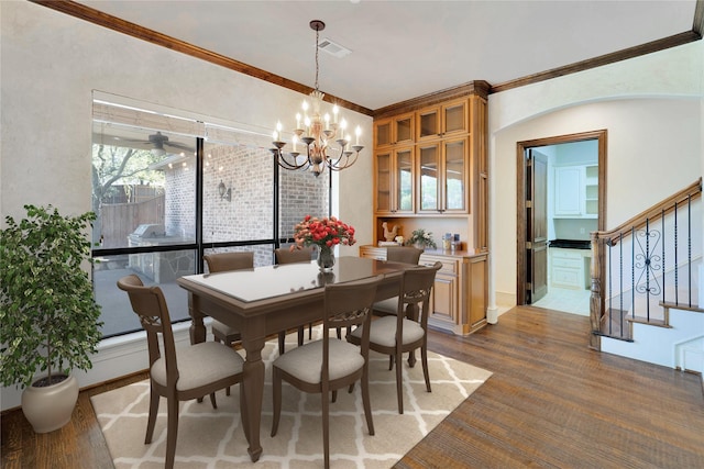 5460 Stone Canyon Dr, Frisco, TX 75034 - dining space with ornamental molding, a chandelier, and stairway