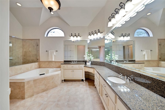5460 Stone Canyon Dr, Frisco, TX 75034 - full bath featuring vaulted ceiling, a bath, a tile shower, two vanities, and tile patterned flooring