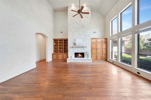 5460 Stone Canyon Dr, Frisco, TX 75034 - unfurnished living room with high vaulted ceiling, healthy amount of natural light, ceiling fan, arched walkways, and wood finished floors
