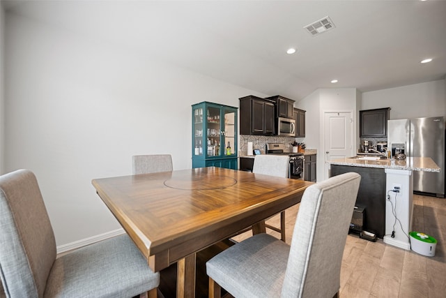 dining space with baseboards, visible vents, light wood-style floors, and recessed lighting