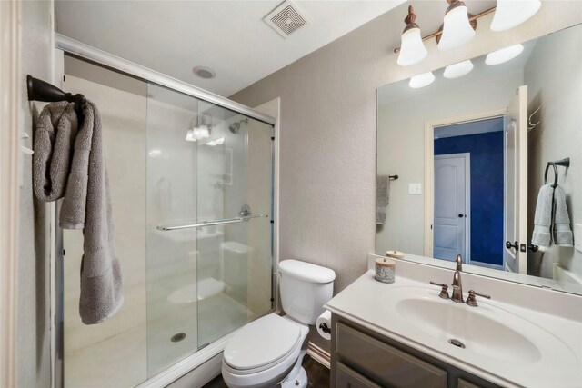 5218 Pueblo Ln, Frisco, TX 75034 - full bath with toilet, vanity, a shower stall, and a textured wall