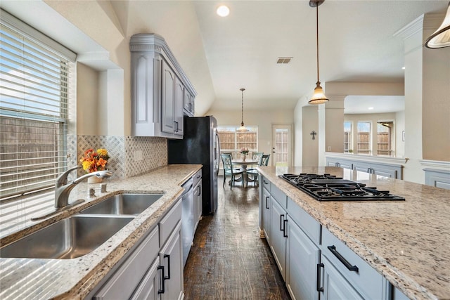 5218 Pueblo Ln, Frisco, TX 75034 - kitchen with a sink, appliances with stainless steel finishes, gray cabinets, decorative backsplash, and decorative light fixtures