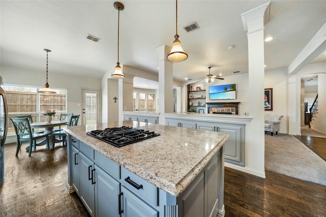 5218 Pueblo Ln, Frisco, TX 75034 - kitchen featuring black gas stovetop, ornate columns, a ceiling fan, dark wood-type flooring, and open floor plan