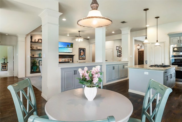 5218 Pueblo Ln, Frisco, TX 75034 - dining space featuring decorative columns, a ceiling fan, dark wood finished floors, recessed lighting, and a fireplace