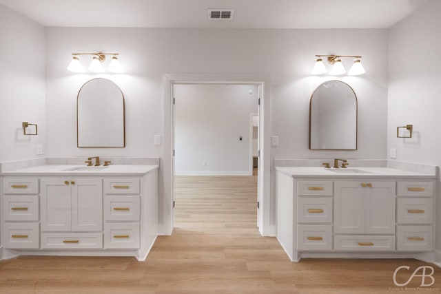 6817 Beals Creek Dr, Abilene, TX 79606 - full bathroom featuring two vanities, a sink, and wood finished floors