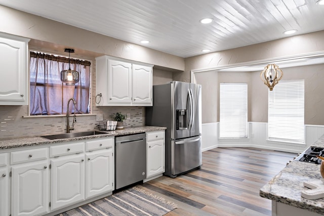kitchen featuring white cabinetry, a sink, stainless steel appliances, and light wood finished floors