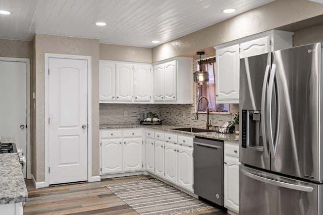 kitchen featuring light wood finished floors, a sink, white cabinetry, and appliances with stainless steel finishes