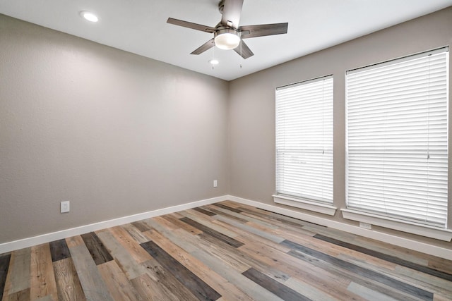 empty room with baseboards, wood finished floors, ceiling fan, and recessed lighting