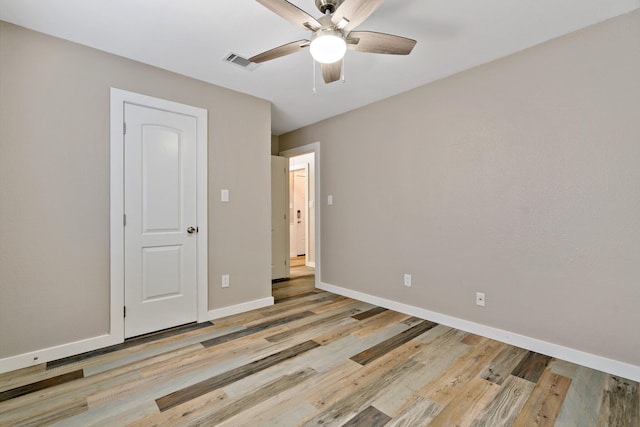 unfurnished bedroom featuring baseboards, visible vents, light wood-style floors, and a ceiling fan