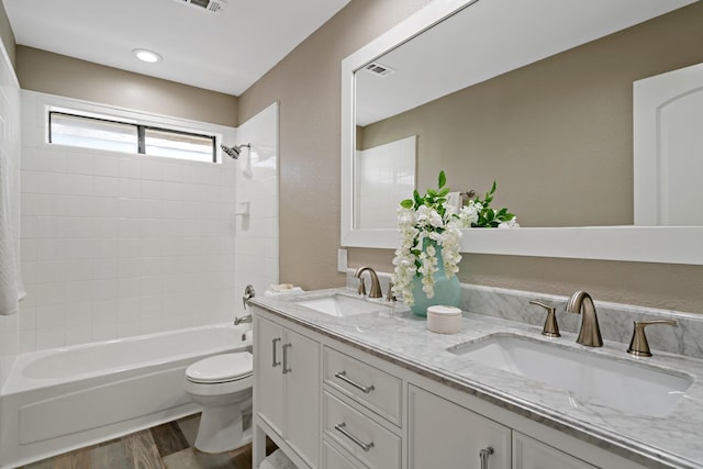 full bath featuring visible vents, wood finished floors, toilet, and a sink