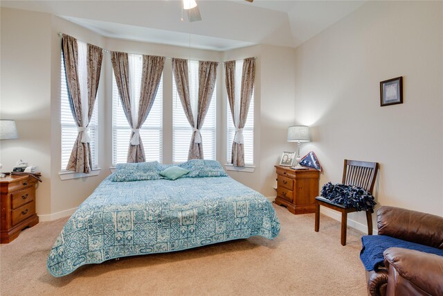 bedroom with light colored carpet, a ceiling fan, and baseboards