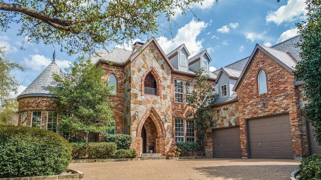 4592 Biltmoore Dr, Frisco, TX 75034 - view of front of house with a garage, stone siding, a high end roof, driveway, and a chimney