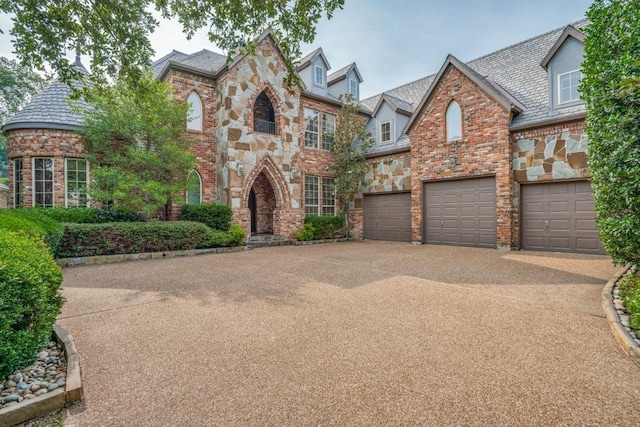 4592 Biltmoore Dr, Frisco, TX 75034 - view of front of house with a high end roof, an attached garage, concrete driveway, and stone siding