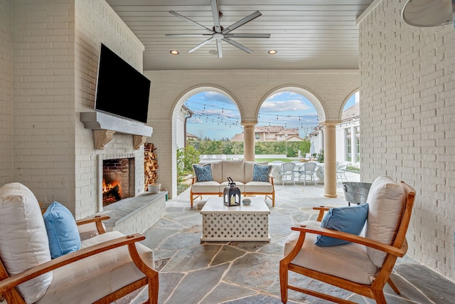 view of patio with outdoor dining space, an outdoor living space with a fireplace, and a ceiling fan