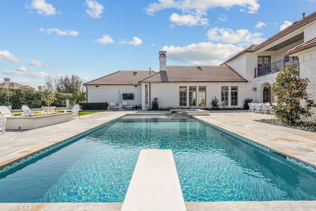 pool with a patio and a diving board