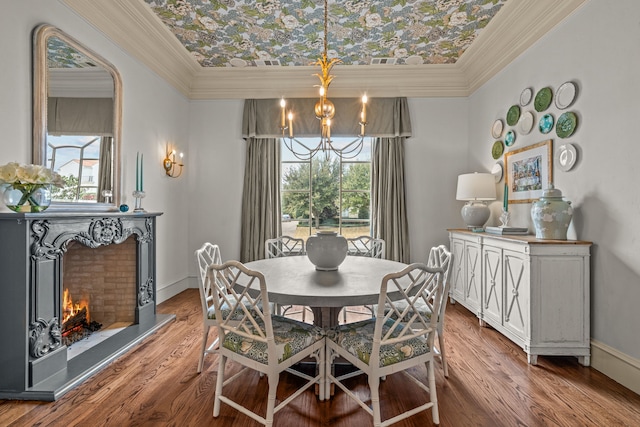 dining space with a notable chandelier, crown molding, baseboards, and wood finished floors
