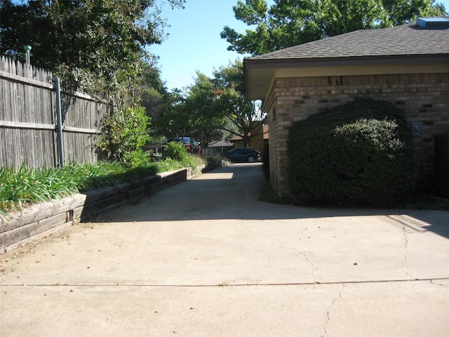 exterior space featuring fence and concrete driveway
