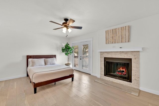 9231 Chimney Corner Ln, Dallas, TX 75243 - bedroom with access to outside, wood finished floors, a stone fireplace, ceiling fan, and french doors