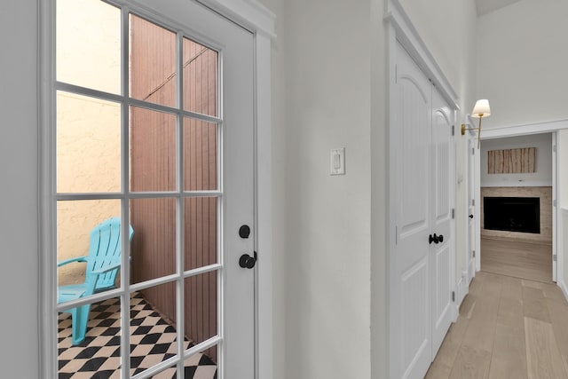 9231 Chimney Corner Ln, Dallas, TX 75243 - doorway to outside featuring a fireplace and light wood finished floors
