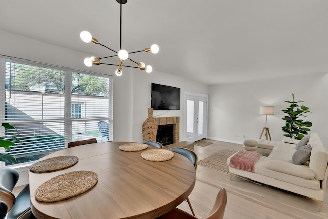 9231 Chimney Corner Ln, Dallas, TX 75243 - dining room with a fireplace, light wood finished floors, and a chandelier