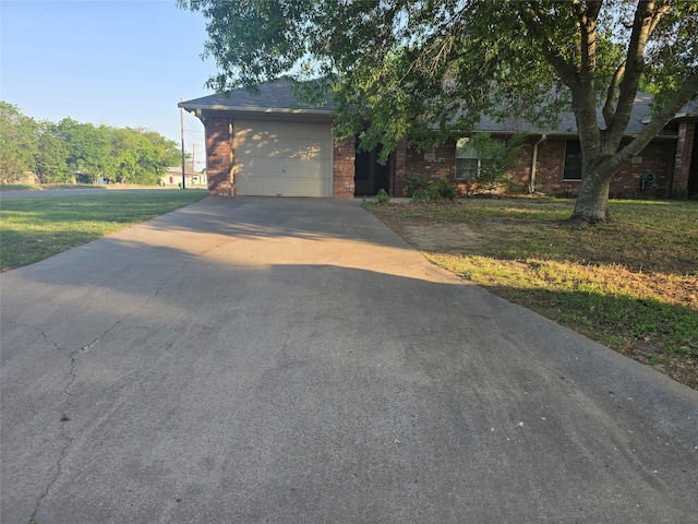 view of front of home with concrete driveway, a front lawn, brick siding, and a garage