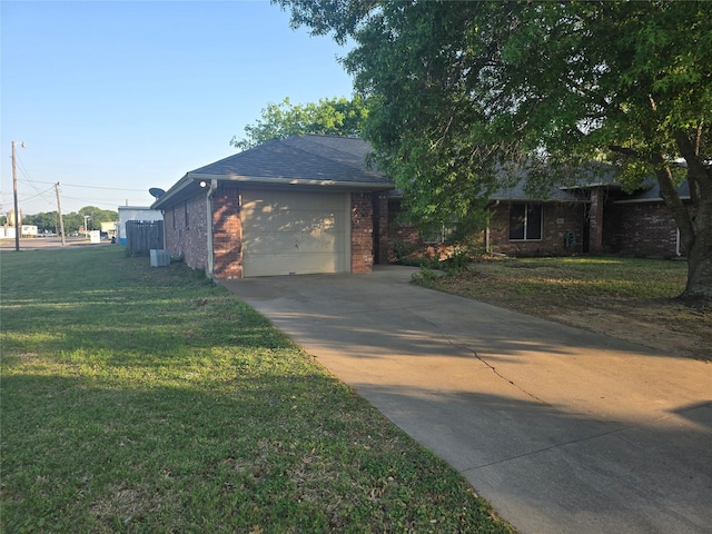 view of side of property with driveway, brick siding, a yard, and a garage