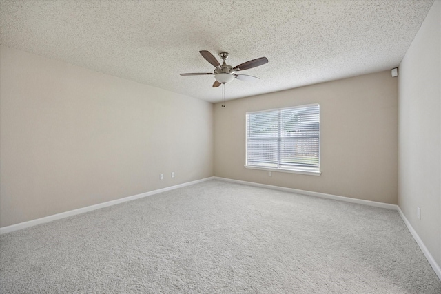 carpeted empty room with ceiling fan, a textured ceiling, and baseboards
