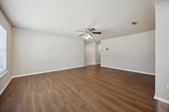 unfurnished room featuring a ceiling fan, wood finished floors, a textured ceiling, and baseboards