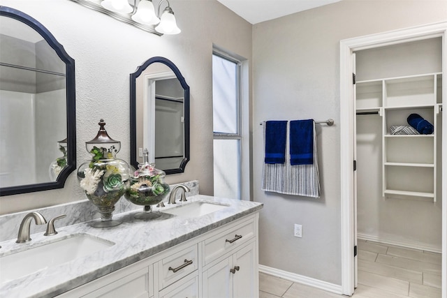608 Concho Dr, Oak Point, TX 75068 - bathroom with double vanity, a walk in closet, and tile patterned flooring