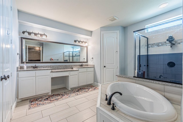 bathroom with a bath, visible vents, double vanity, a sink, and a stall shower