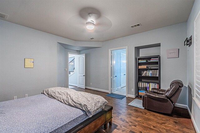 bedroom featuring dark wood finished floors, baseboards, visible vents, and ceiling fan