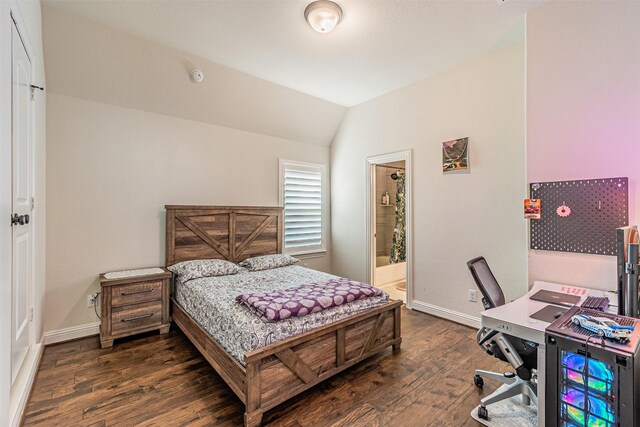 bedroom featuring dark wood-type flooring, lofted ceiling, connected bathroom, and baseboards