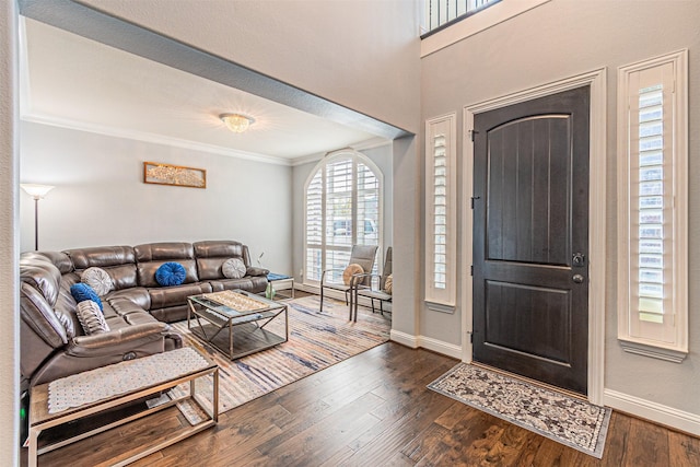foyer entrance with ornamental molding, dark wood-style floors, and baseboards