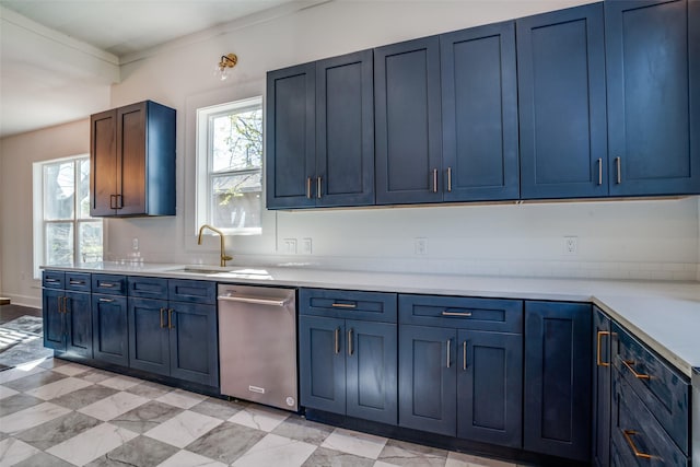 kitchen featuring light countertops, a sink, blue cabinets, and a wealth of natural light