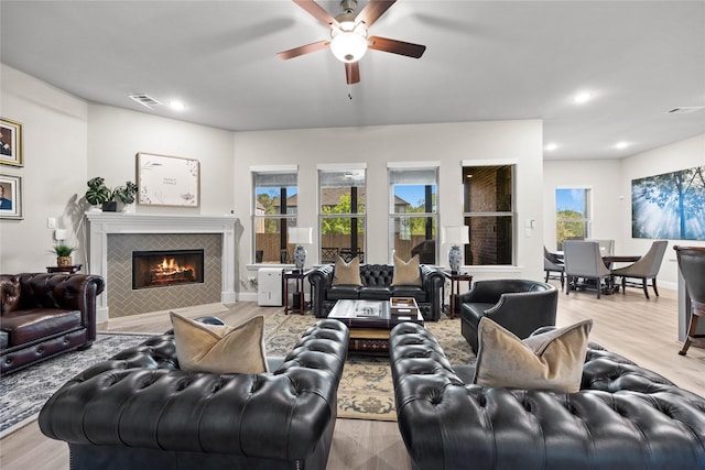 living room featuring recessed lighting, a tile fireplace, wood finished floors, and ceiling fan