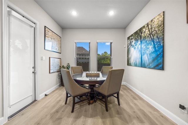 dining room with baseboards, light wood finished floors, and recessed lighting